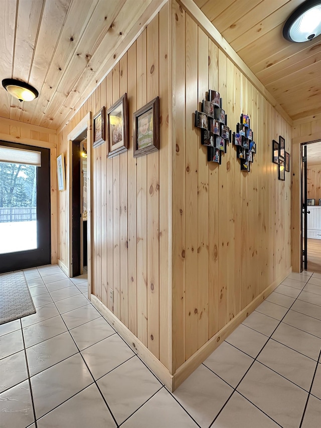 hall with wooden ceiling, wood walls, and light tile patterned flooring