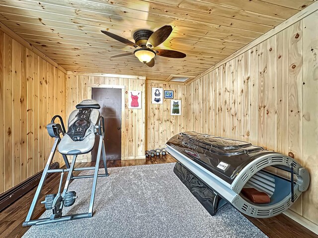 bedroom with wood walls, wooden ceiling, wood finished floors, and attic access