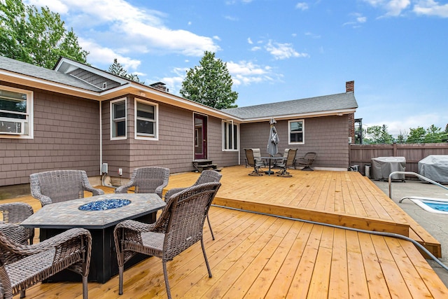 wooden terrace featuring a grill and a fire pit