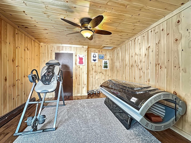 workout area with hardwood / wood-style flooring, ceiling fan, wood ceiling, and wooden walls