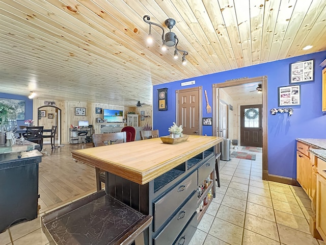 kitchen with light tile patterned floors, light countertops, light brown cabinetry, and wooden ceiling