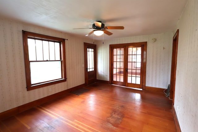 empty room featuring ceiling fan, french doors, and wood-type flooring