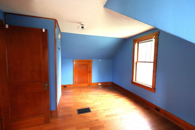 bonus room with light hardwood / wood-style flooring and lofted ceiling