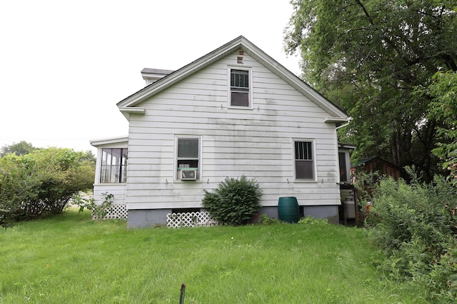 view of home's exterior with cooling unit and a yard