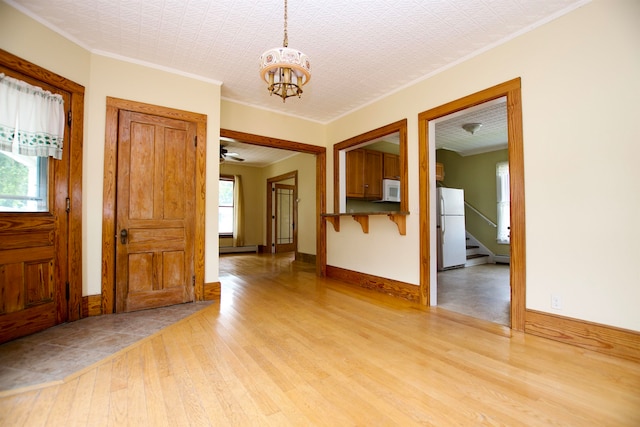 spare room with light hardwood / wood-style floors, crown molding, and a textured ceiling