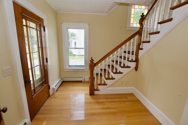 entryway with light wood-type flooring and a baseboard radiator