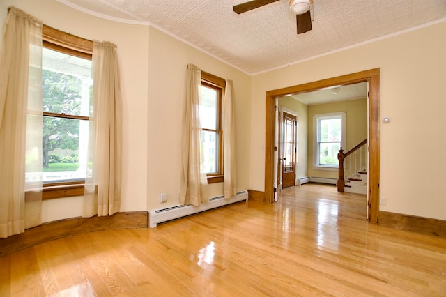 interior space featuring light hardwood / wood-style flooring, ornamental molding, a textured ceiling, ceiling fan, and baseboard heating