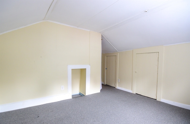 additional living space featuring light carpet and vaulted ceiling