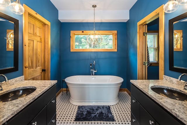 bathroom with an inviting chandelier, vanity, and a bathtub