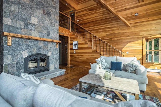 living room featuring a towering ceiling, wood-type flooring, and wooden walls