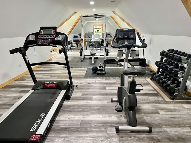 exercise room with hardwood / wood-style flooring and vaulted ceiling