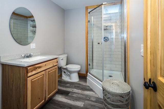 bathroom featuring hardwood / wood-style floors, vanity, walk in shower, and toilet