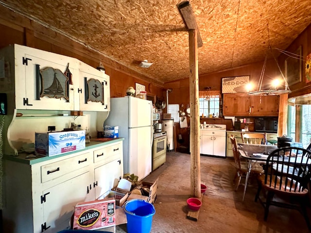 kitchen with plenty of natural light, lofted ceiling, range, and white refrigerator