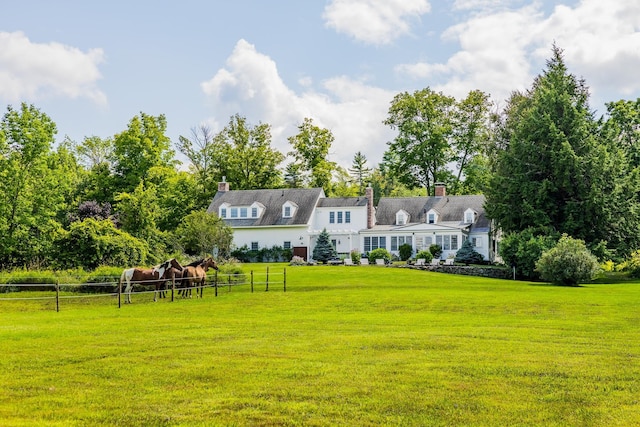 rear view of house with a yard and fence
