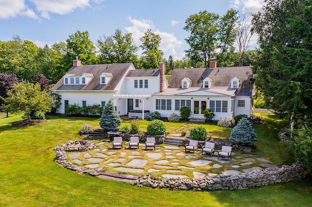 rear view of house with a pergola, a patio area, a yard, and a chimney