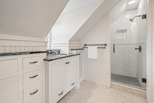 full bath with vanity, a stall shower, and lofted ceiling