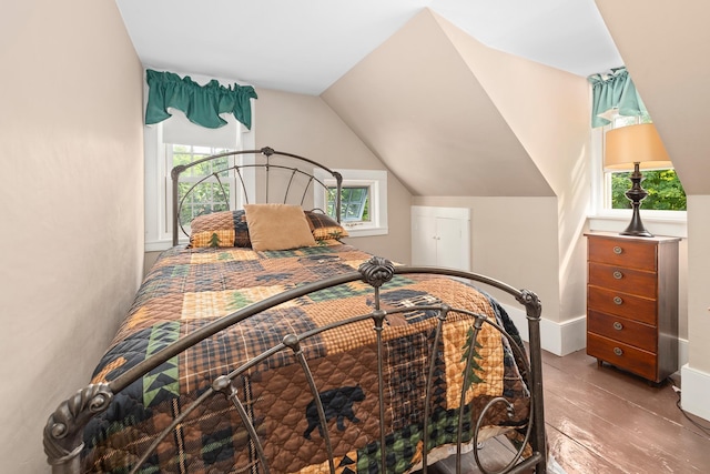 bedroom with baseboards and lofted ceiling