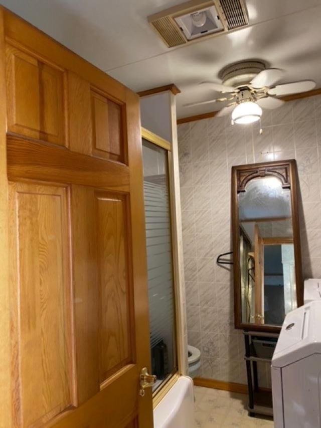 bathroom with washer / clothes dryer, ceiling fan, and toilet