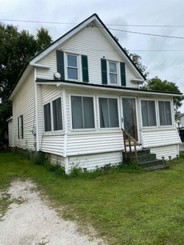 view of front of home featuring a front lawn and a sunroom