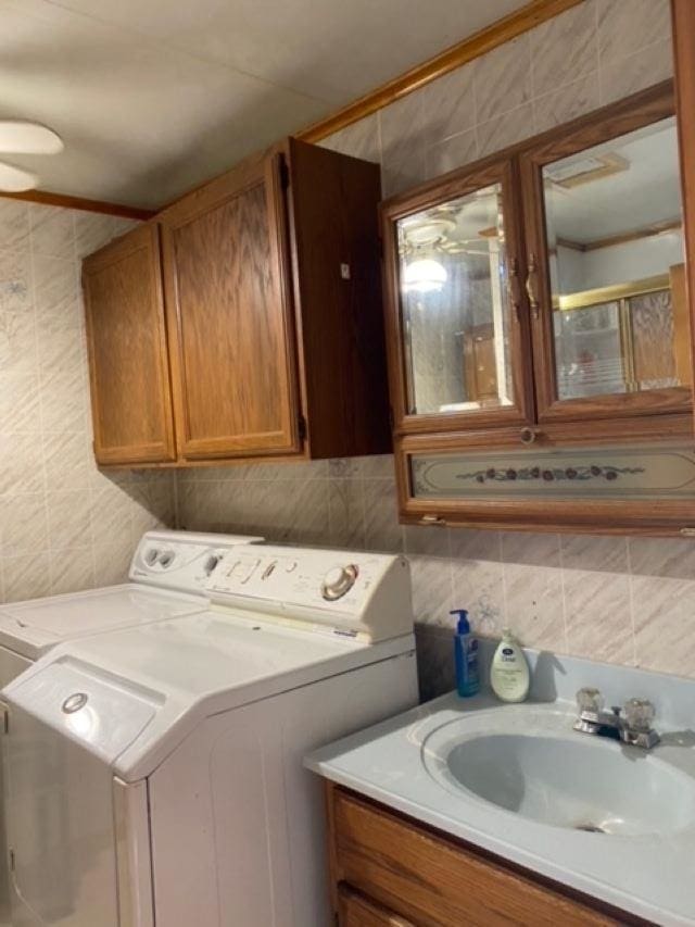 clothes washing area featuring ceiling fan, sink, and independent washer and dryer