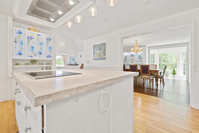 kitchen with light wood-style floors, plenty of natural light, light countertops, and black electric cooktop