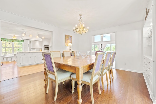 dining area featuring light wood-style floors and a notable chandelier