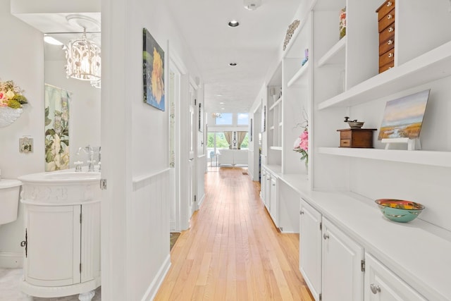 hall featuring recessed lighting, a notable chandelier, and light wood finished floors