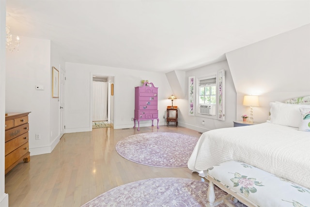 bedroom with light wood-type flooring, cooling unit, and baseboards