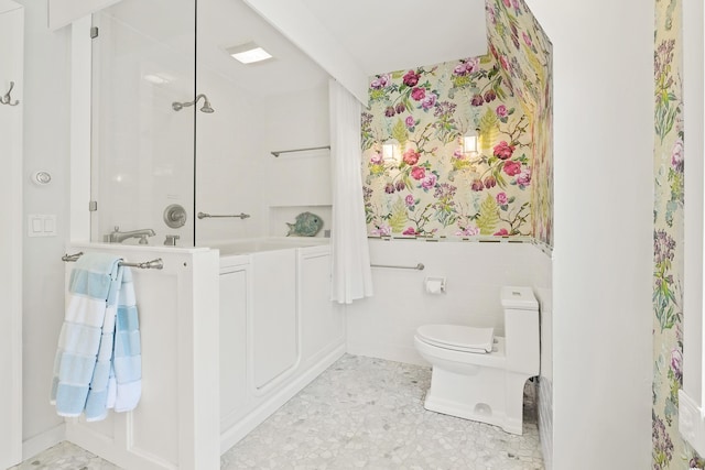 bathroom with a shower, toilet, and tile walls