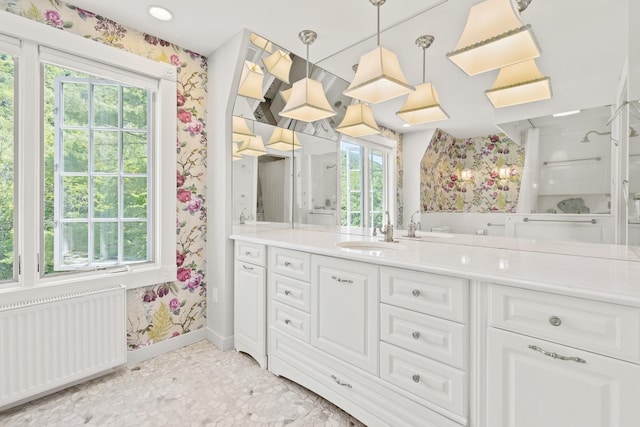 full bath featuring radiator heating unit, vanity, wallpapered walls, and baseboards