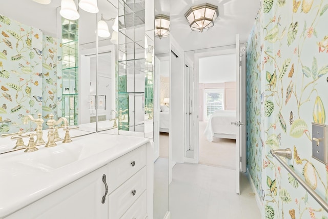 bathroom with tile patterned floors, vanity, wallpapered walls, and connected bathroom