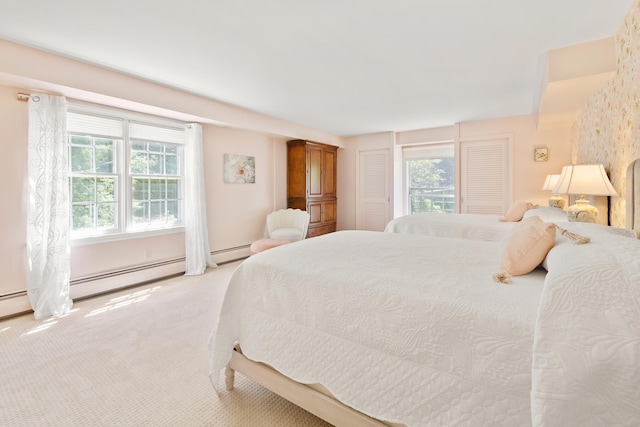 bedroom with a baseboard radiator and light carpet