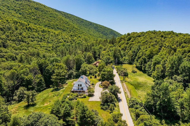 birds eye view of property featuring a wooded view and a mountain view