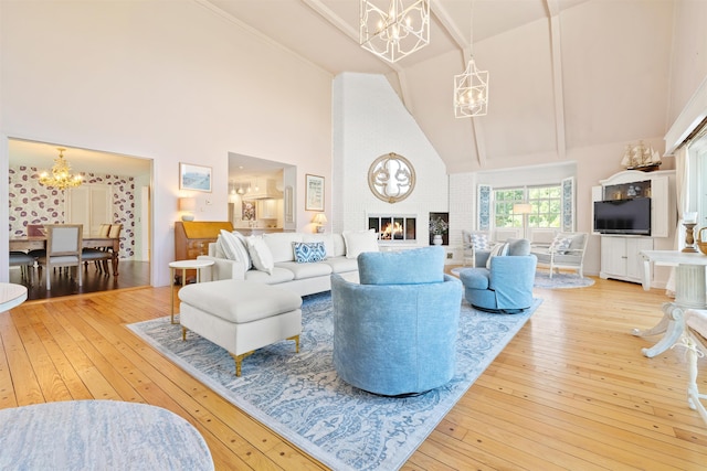 living area with a fireplace, a chandelier, hardwood / wood-style floors, and high vaulted ceiling
