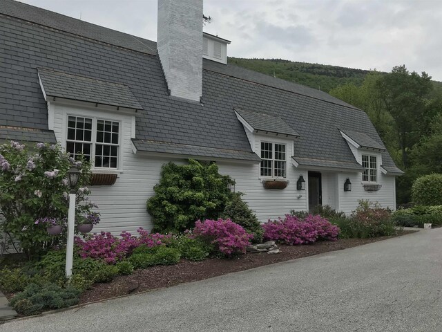 view of front of house featuring a high end roof and a chimney