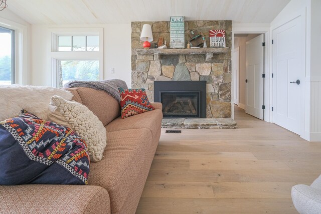 living room with a fireplace, hardwood / wood-style flooring, and vaulted ceiling