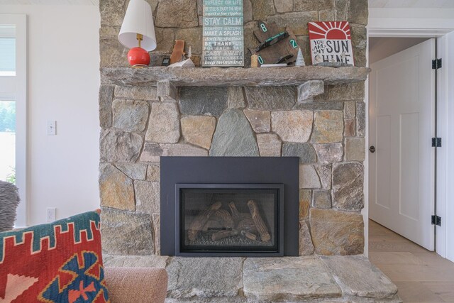 room details with hardwood / wood-style floors and a stone fireplace