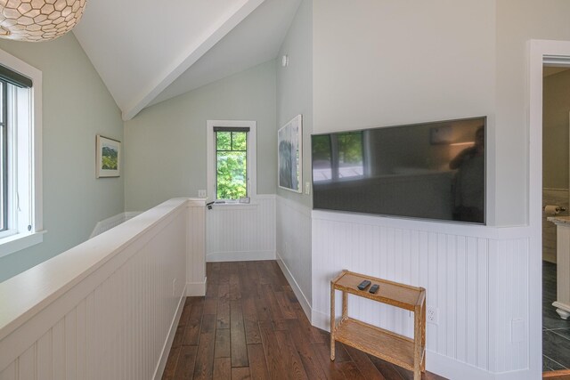 bedroom featuring dark hardwood / wood-style floors, a baseboard heating unit, lofted ceiling, and multiple windows