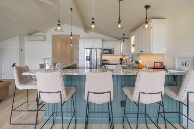 kitchen with stainless steel fridge with ice dispenser, pendant lighting, white cabinetry, and a breakfast bar area