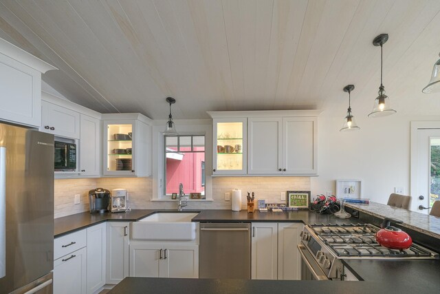 kitchen featuring appliances with stainless steel finishes, backsplash, sink, white cabinetry, and hanging light fixtures