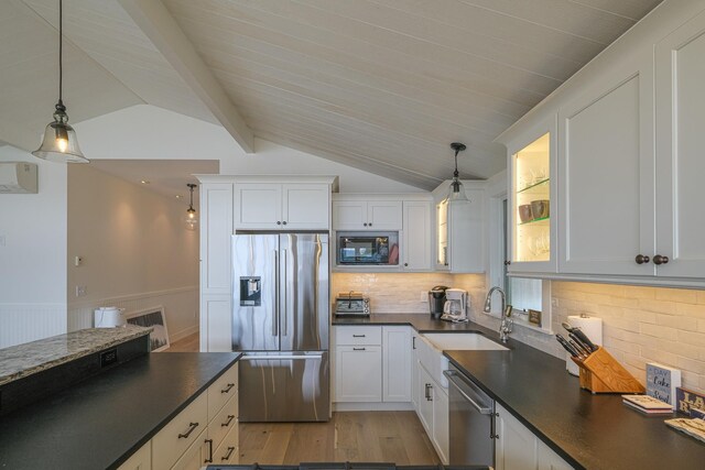 kitchen featuring vaulted ceiling with beams, white cabinetry, light wood-type flooring, and stainless steel appliances