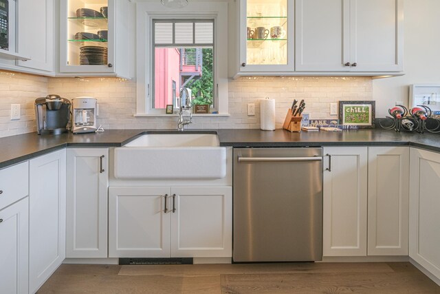 kitchen featuring tasteful backsplash, white cabinetry, sink, and stainless steel dishwasher