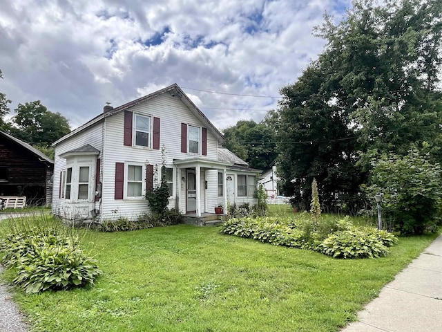 view of front of home featuring a chimney and a front yard