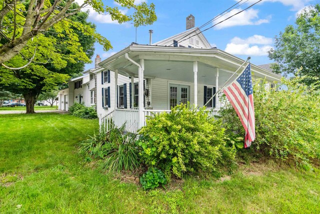 14 School St, Highgate, VT 05459 - view of side of property with covered porch, a yard, and a chimney