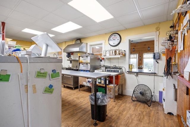 kitchen featuring a drop ceiling, wood finished floors, and freestanding refrigerator