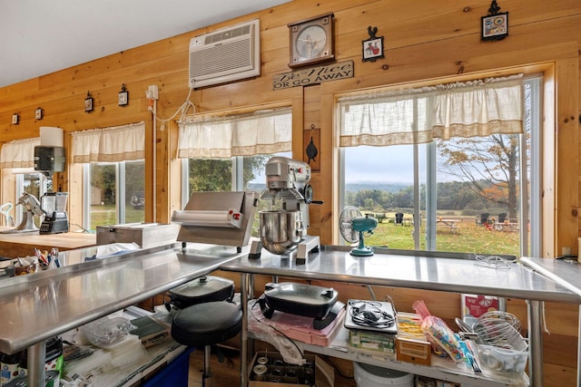 kitchen featuring a healthy amount of sunlight, wood walls, and a wall mounted AC