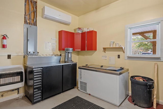 kitchen with heating unit, electric panel, concrete flooring, and a wall mounted AC