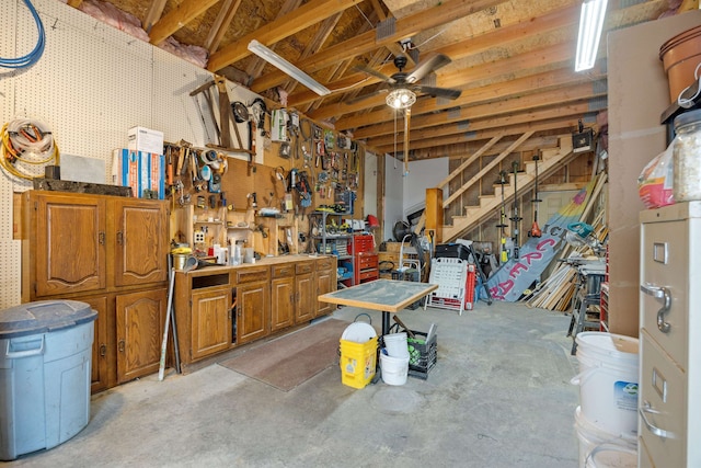 below grade area featuring a ceiling fan and a workshop area