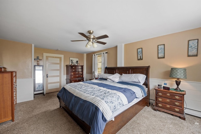 bedroom featuring carpet floors, a baseboard radiator, wainscoting, and a ceiling fan