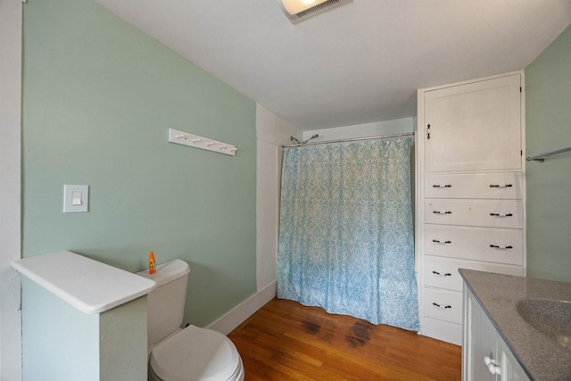 full bath with visible vents, a shower with shower curtain, toilet, vanity, and wood finished floors